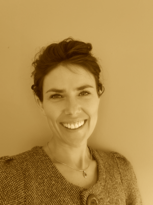 Headshot of a woman with a business jacket and it's tinted gold